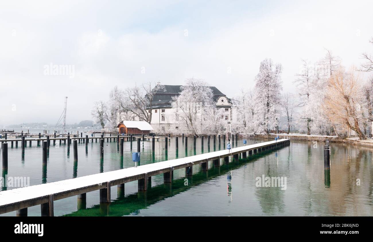 Jetée sur le lac Attersee et architecture typique par une journée d'hiver enneigée Banque D'Images