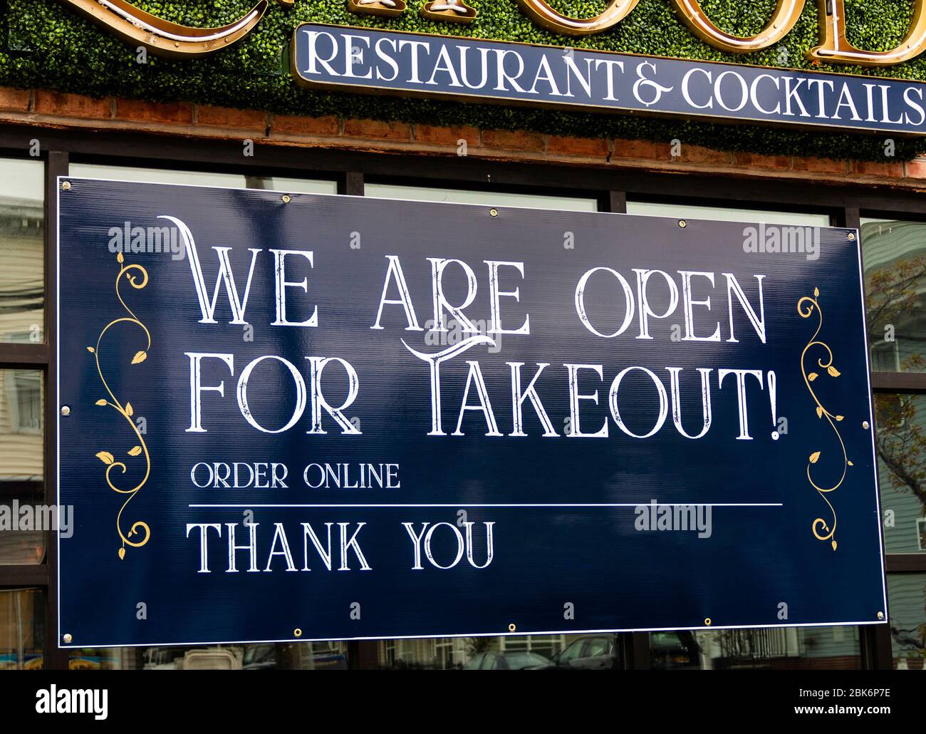 Grand panneau bleu dans la fenêtre du restaurant nous sommes ouverts pour la commande de plats à emporter en ligne et merci pendant la pandémie de coronavirus COVID-19. Banque D'Images Grand panneau bleu dans la fenêtre du restaurant nous sommes ouverts pour la commande de plats à emporter en ligne et merci pendant la pandémie de coronavirus COVID-19. Banque D'Images
