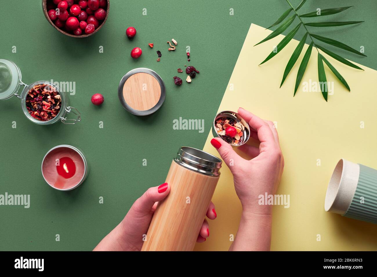 Zéro déchet de thé à emporter, en infusion de plantes dans une fiole en acier de bambou isolée écologique avec mélange de plantes et de canneberges. Créatif branché f Banque D'Images