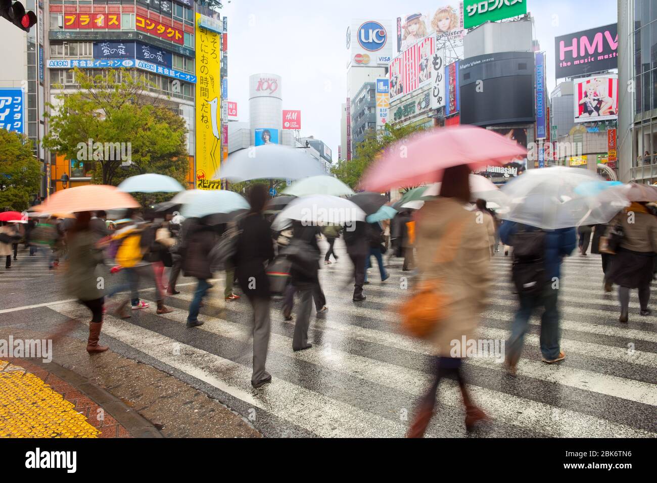 Shibuya, Tokyo, région de Kanto, Honshu, Japon - les gens traversant la rue sous la pluie avec des parasols dans le district de Shibuya. Banque D'Images