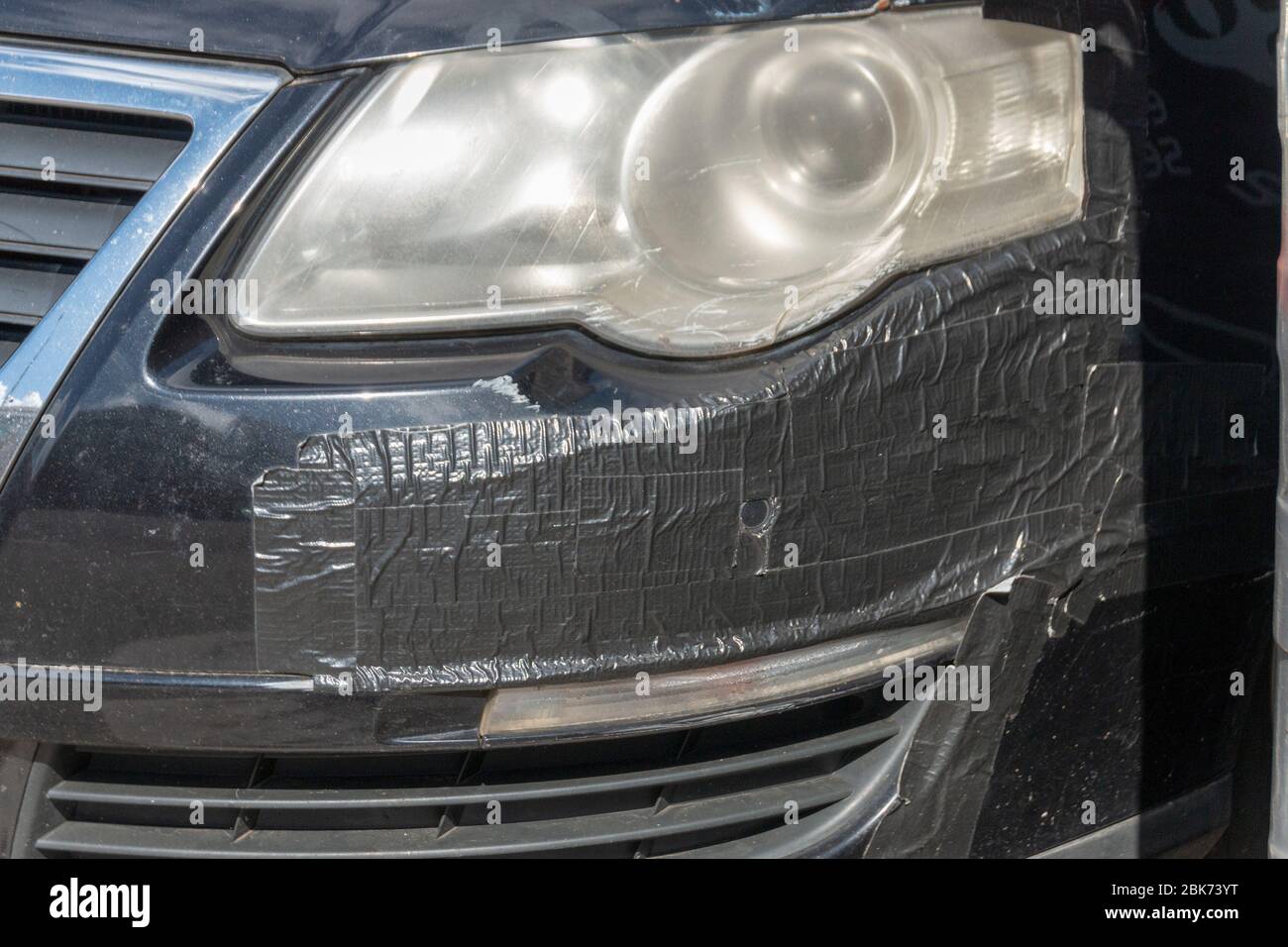 vue rapprochée d'une voiture qui a été piar avec du ruban de canard noir sur le pare-chocs avant Banque D'Images