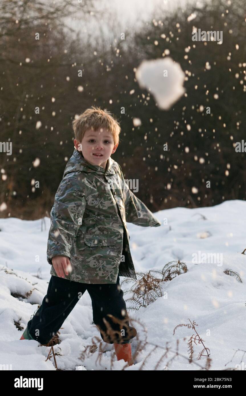 Un jeune garçon jette un boule de neige Kelling Norfolk décembre Banque D'Images
