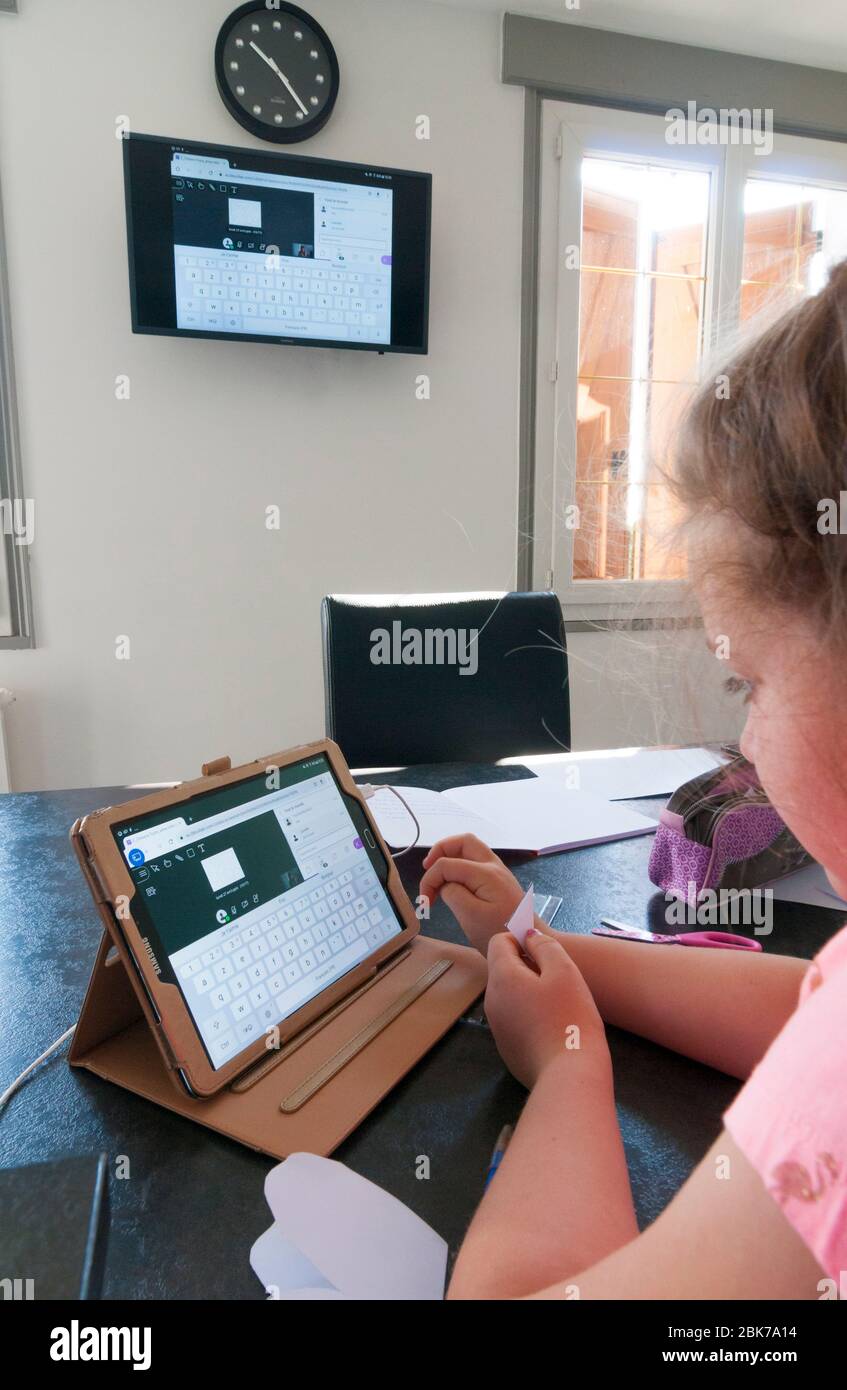 France, Loiret (45 ans), Covid-19 verrouillage français le 04/27/2020, jeune fille de 7 ans au   cours de la classe scolaire virtuelle à la maison à l'aide d'une tablette à distance Banque D'Images