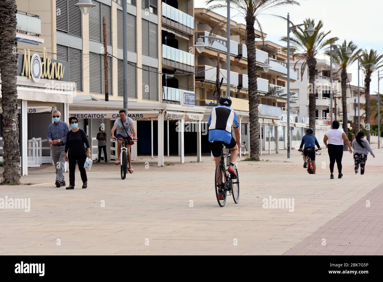 Plusieurs personnes marchant et pédaler le long d'une rue à la plage.l'Espagne soulève certaines restrictions d'état d'alarme dans lesquelles les gens peuvent aller faire des sports individuels entre 6 h et 10 h et entre 20 h et 23 h la nuit. Les personnes à charge qui doivent sortir accompagnés sont réservées un horaire de 10 h à 12 h et de 19 h à 20 h. Banque D'Images