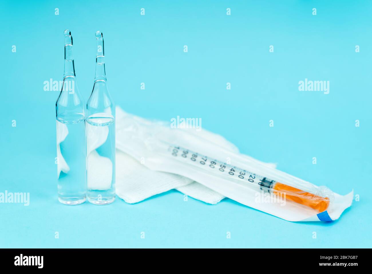 seringue et ampoule avec vaccin se trouvent sur un fond bleu avec de l'espace pour le texte Banque D'Images