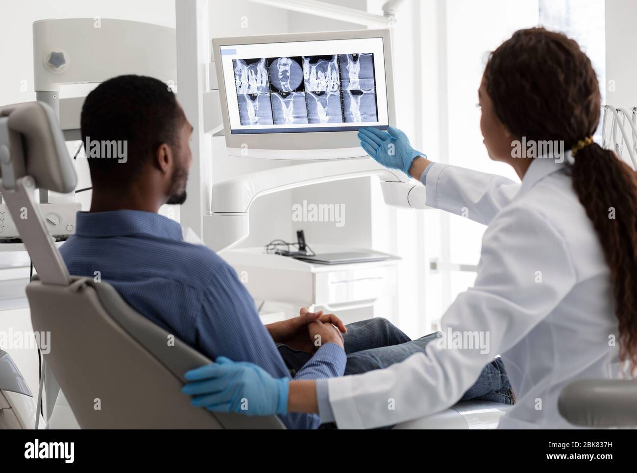 Dentiste féminin pointant vers l'écran avec image de radiographie Banque D'Images