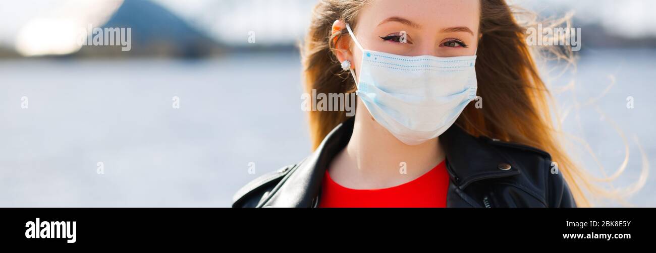 Bannière: Belle femme dans le masque chirurgical vous regarde Banque D'Images