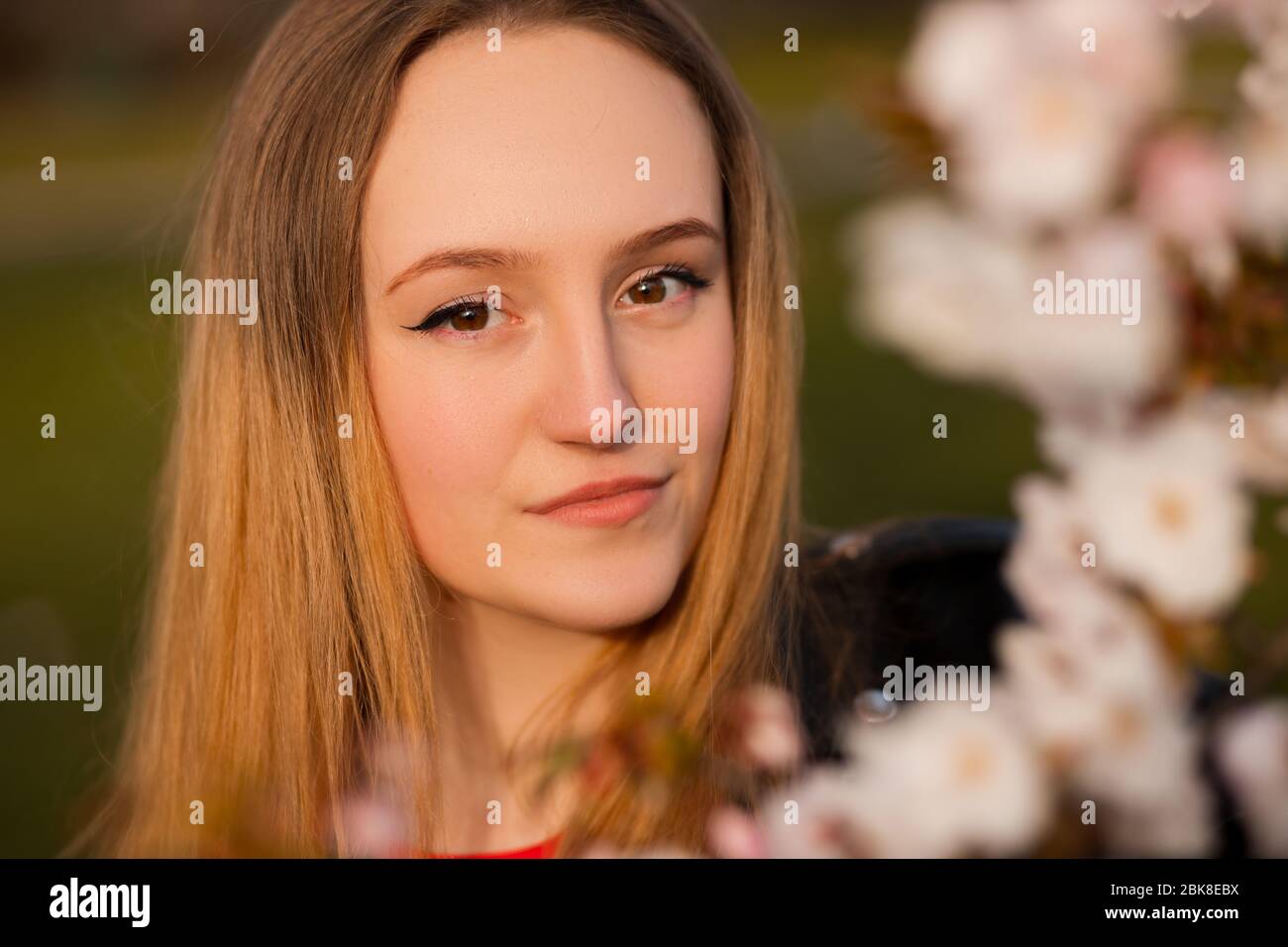Portrait de la belle blonde femme avec branche sakura Banque D'Images