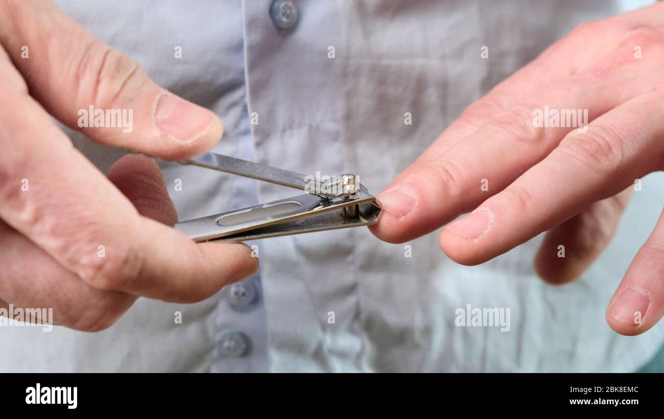 Couper les ongles sur une main d'homme avec des pinces à ongles. Gros plan. Banque D'Images