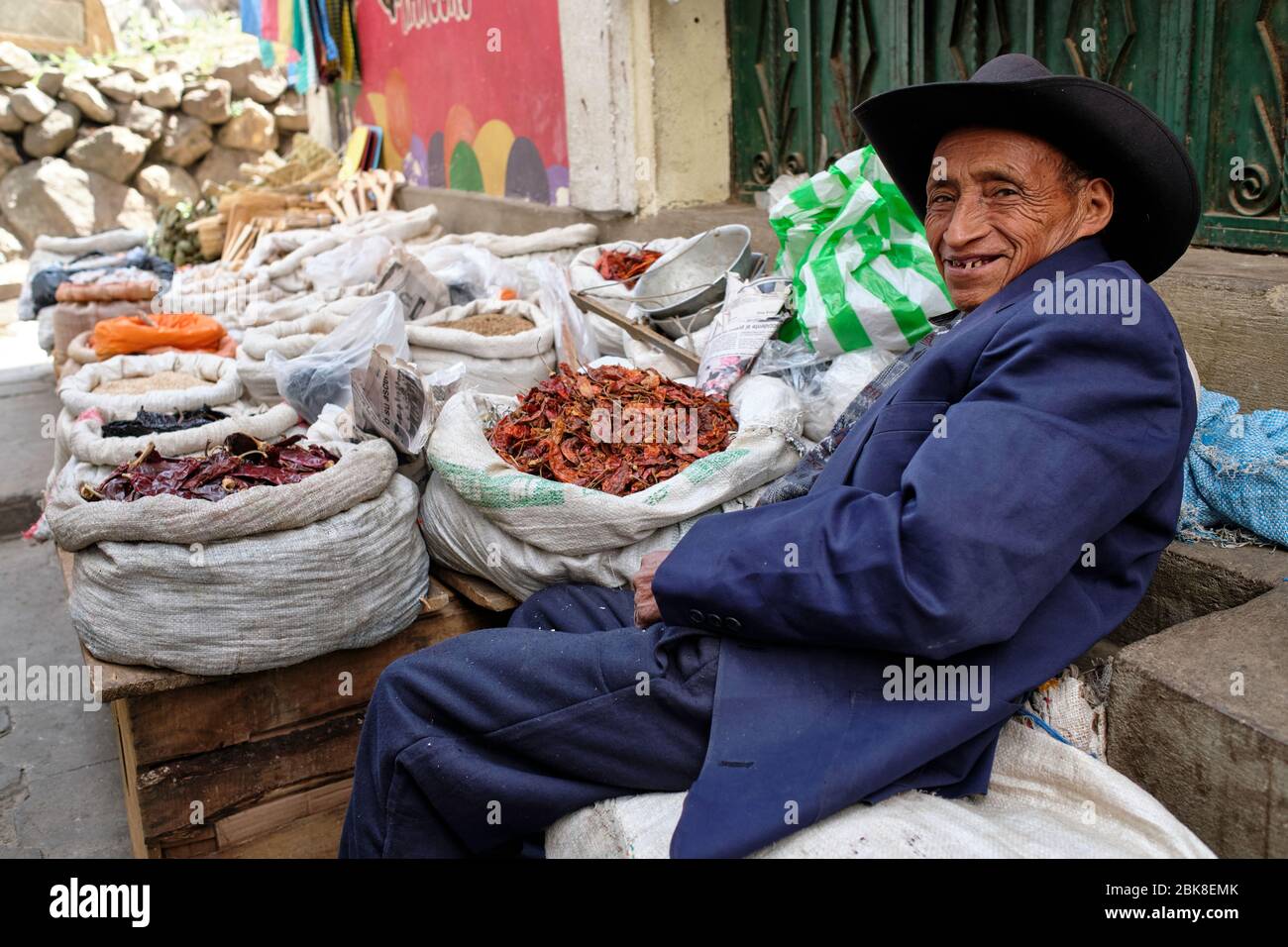 Vieil homme vendant des légumes secs dans un marché de rue. Banque D'Images