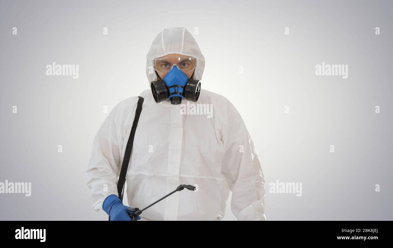 Désinfectant marchant avec réservoir de liquide antiviral regardant la caméra sur fond gradient. Banque D'Images