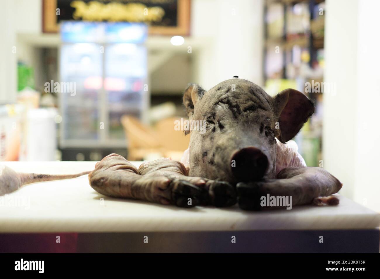 Une tête de cochons est assise sur une table de bouchers dans une vente humide à Kunming, en Chine. Banque D'Images