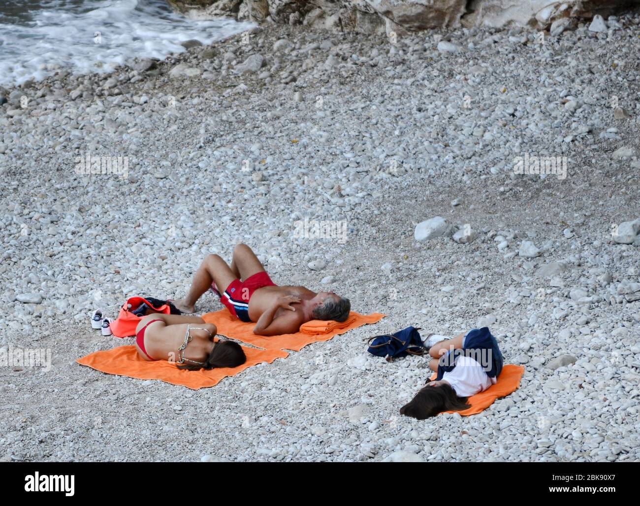 Tourisme dormant sur la magnifique et rocheuse plage de Sveti Jakov, à la périphérie de Dubrovnik, en Croatie. Banque D'Images