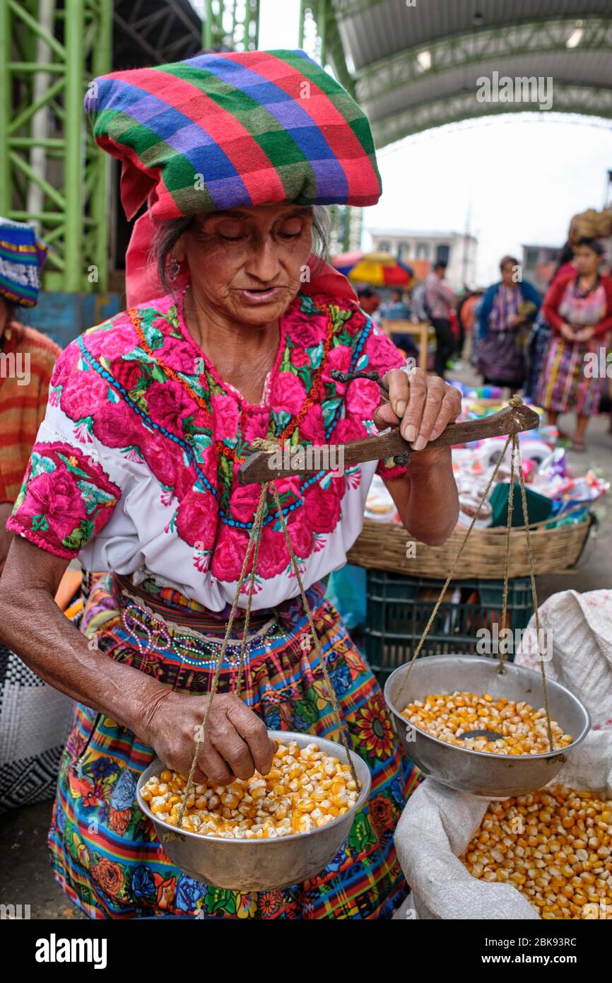 Femme vêtue d'une tenue colorée indigène vendant du maïs sur un marché local. Banque D'Images