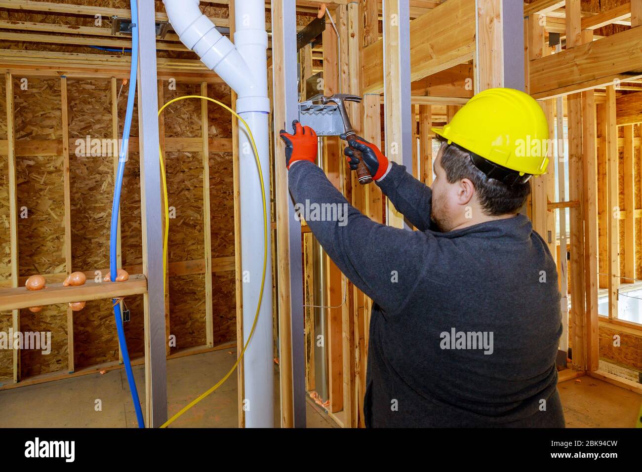 Le travailleur met sur l'installation des prises électriques dans une nouvelle maison Banque D'Images