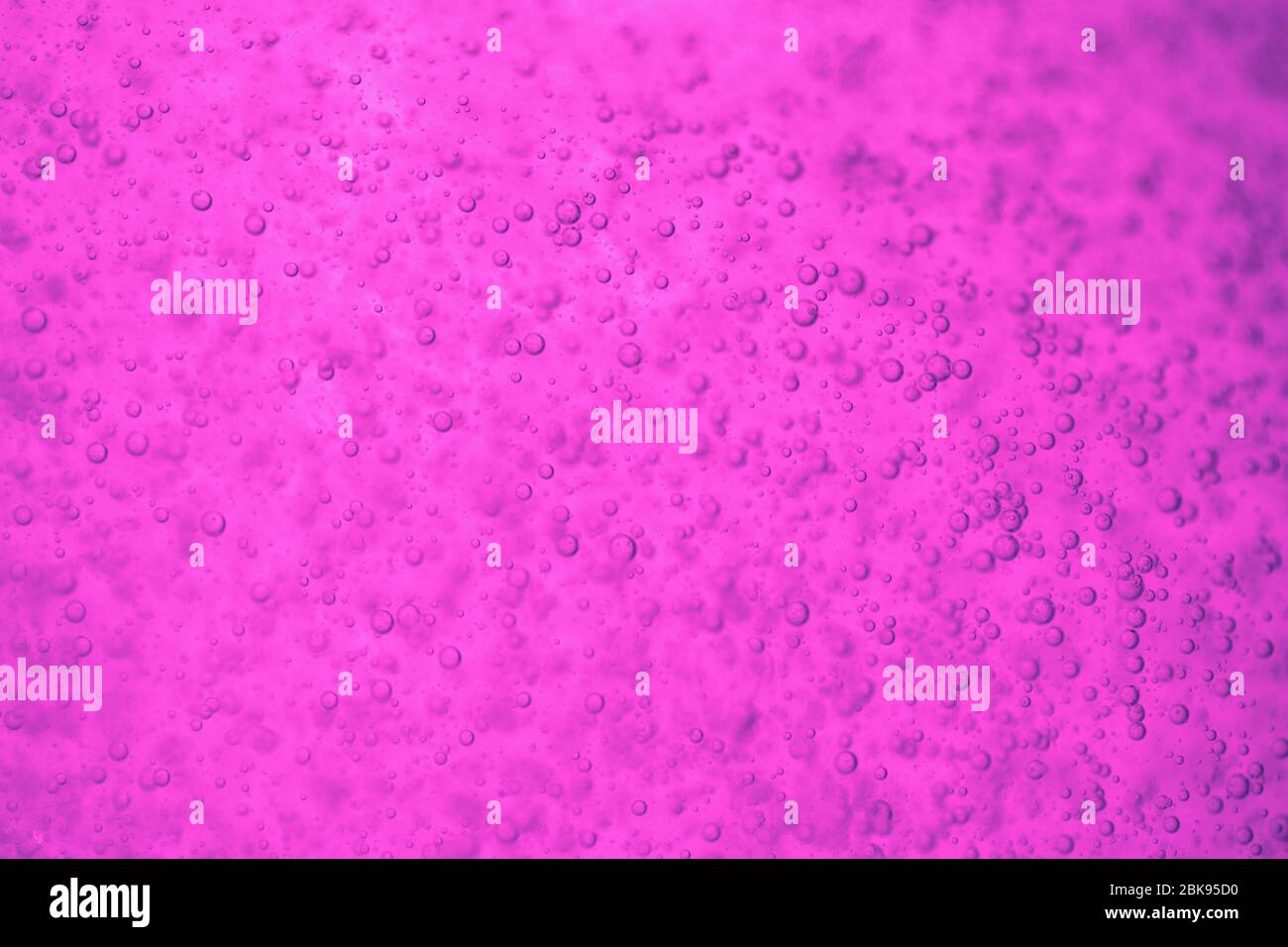 Liquide rose, violet, vif et vif avec bulles. Banque D'Images
