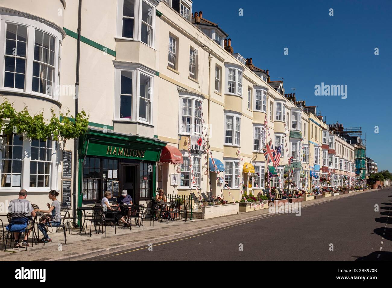 Maisons et B&B géorgiens décorés de petits pains le long de l'esplanade de Weymouth lors d'une journée d'été ensoleillée à Dorset, en Angleterre Banque D'Images