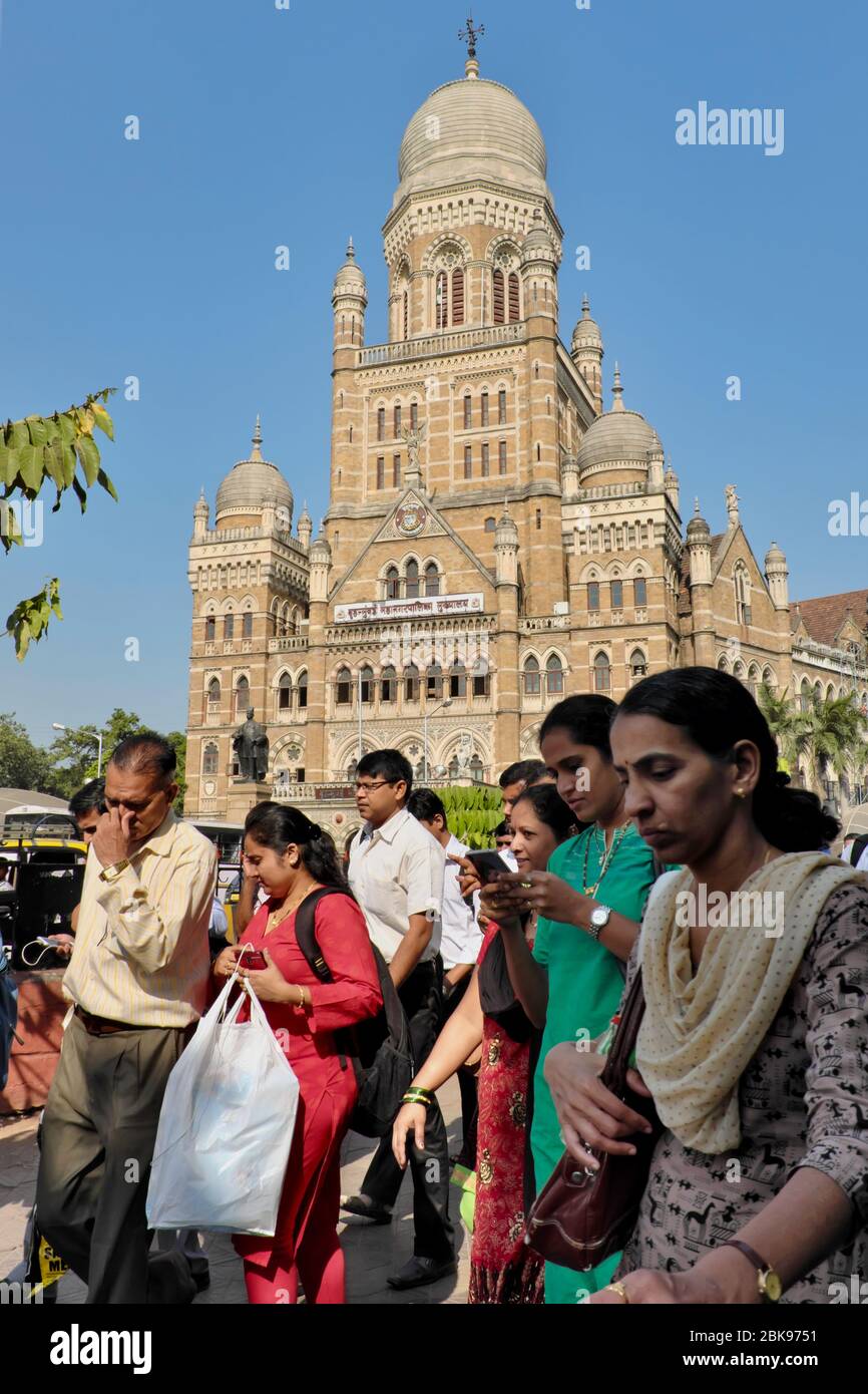 Les navetteurs à l'extérieur de Chhatrapati Shivaji Maharaj Terminus (CSMT) à Mumbai, Inde, le bldg. De la Corporation municipale de Bombay (BMC) en arrière-plan Banque D'Images