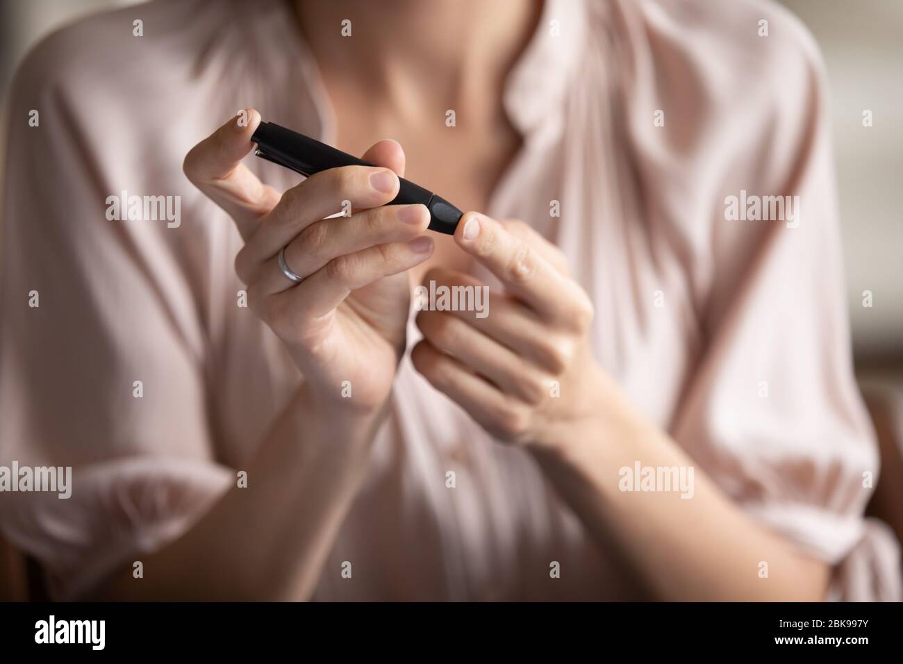 Gros plan jeune femme mesurant le niveau de glucose, à l'aide d'un stylo lancet Banque D'Images