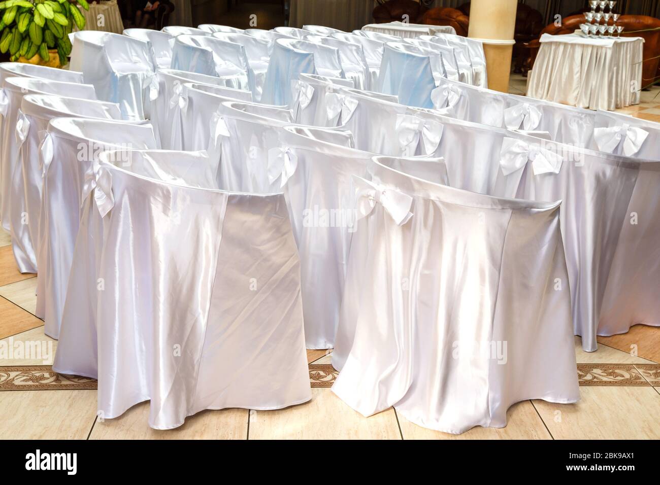 Chaises recouvertes de tissu blanc sur la cérémonie de mariage dans les rangées Banque D'Images