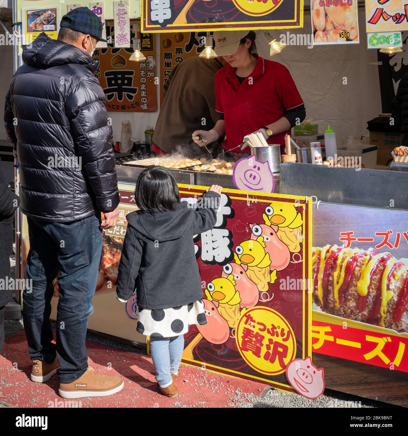 Fille achetant la restauration rapide avec Père au Japon Banque D'Images