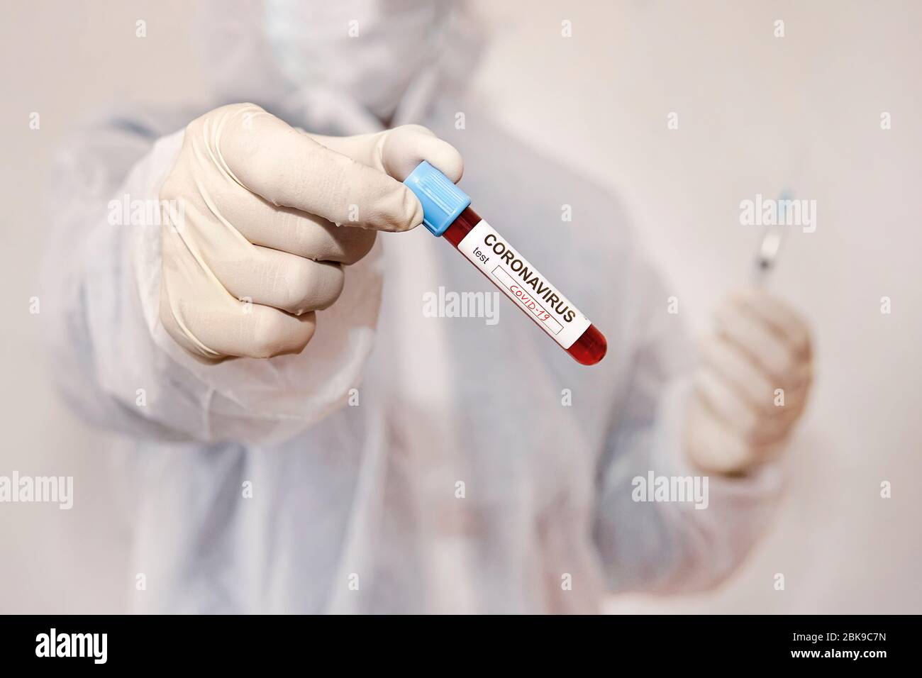 Coronavirus covid 19 flacon de sang infecté dans la main d'un médecin féminin avec masque chirurgical et lucarne. Corona virus covid 19 laboratoire de réasach, coronavirus Banque D'Images