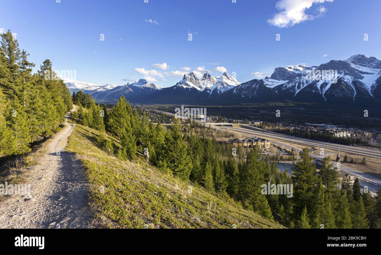 Panorama de paysage printanier, vallée de la Bow et ville de Canmore avec le pic de montagne de trois Sœurs à Horizon. Alberta Foothills Rocheuses canadiennes Banque D'Images