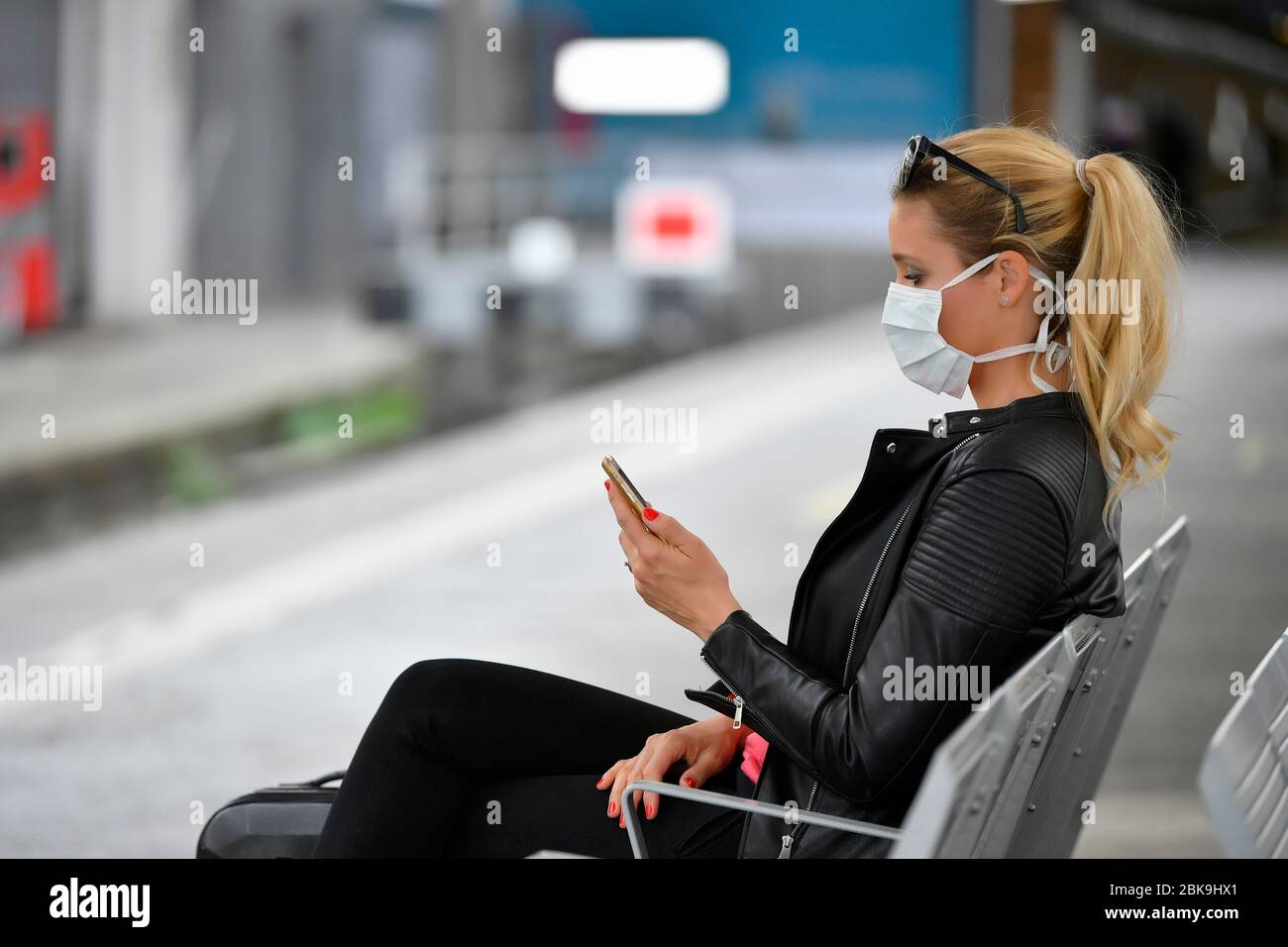 Femme avec masque, en attente de train, sur téléphone mobile, crise corona, gare centrale, Stuttgart, Bade-Wuerttemberg, Allemagne Banque D'Images