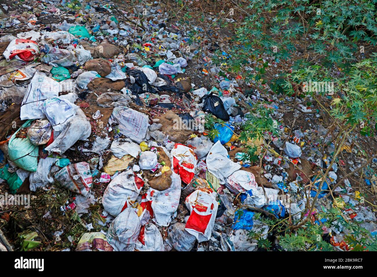 Décharge illégale près de la route dans la ville. Pollution des déchets dans la nature. Vidage sale près de la route Banque D'Images