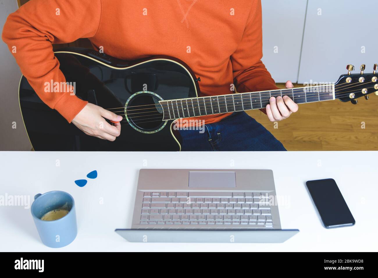 homme caucasien prenant des leçons de guitare acoustique avec ordinateur Banque D'Images