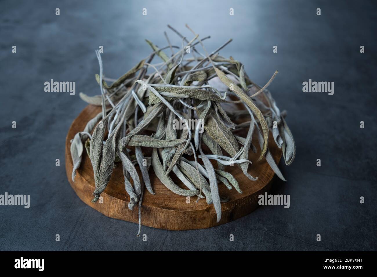 Sauge sèche, thé salvia dans une plaque de service en bois sur béton, fond en pierre. Herbiers biologiques, sains et relaxants. Banque D'Images Sauge sèche, thé salvia dans une plaque de service en bois sur béton, fond en pierre. Herbiers biologiques, sains et relaxants. Banque D'Images