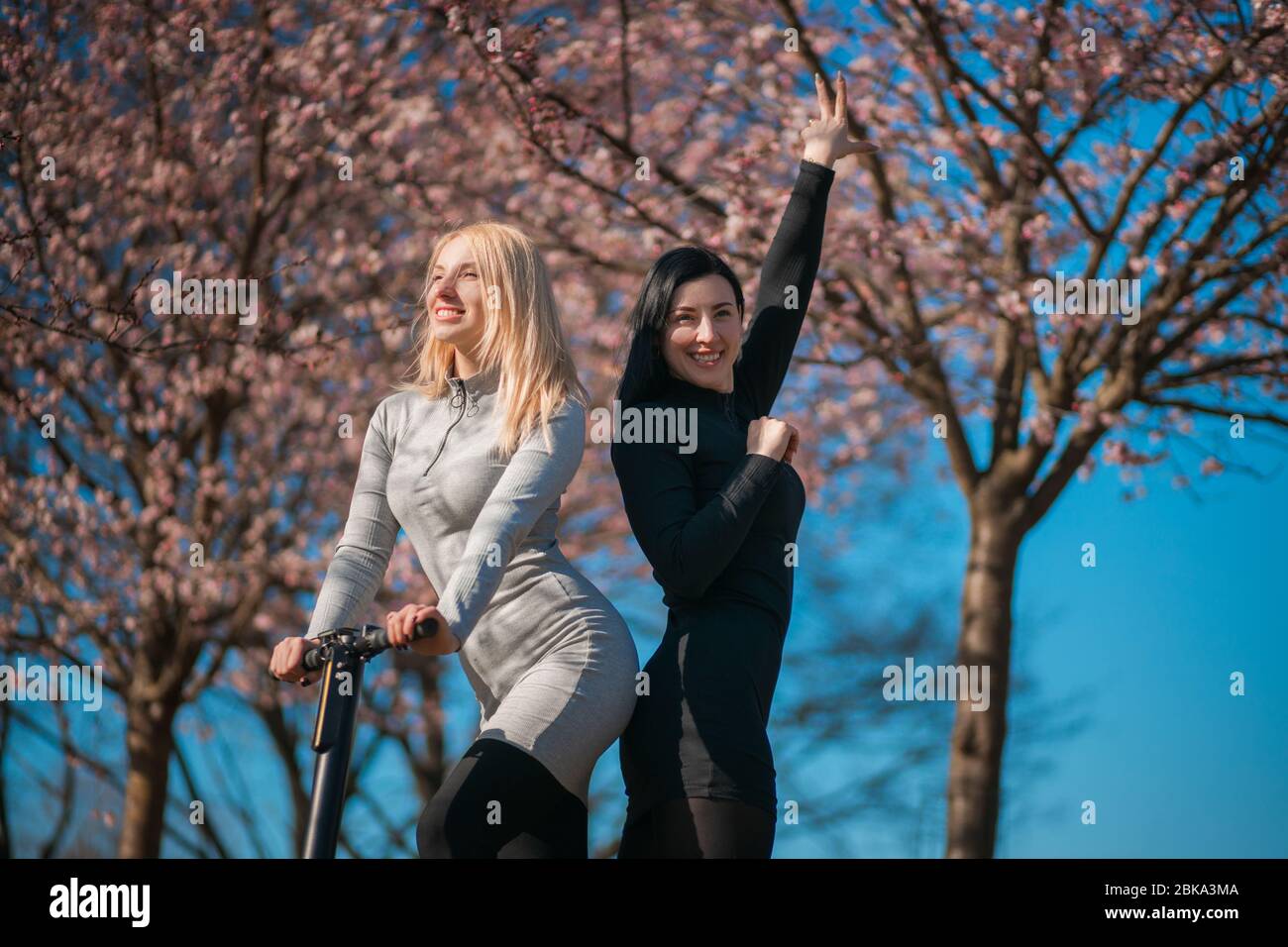 Joyeuses sœurs blonde et brunette dans le parc de la ville le week-end Banque D'Images
