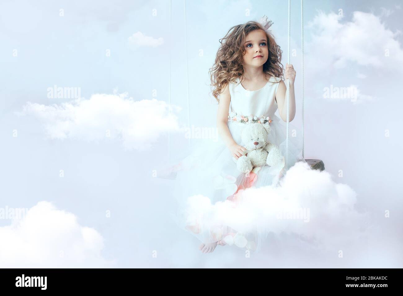 petite fille est assise sur le nuage Banque D'Images