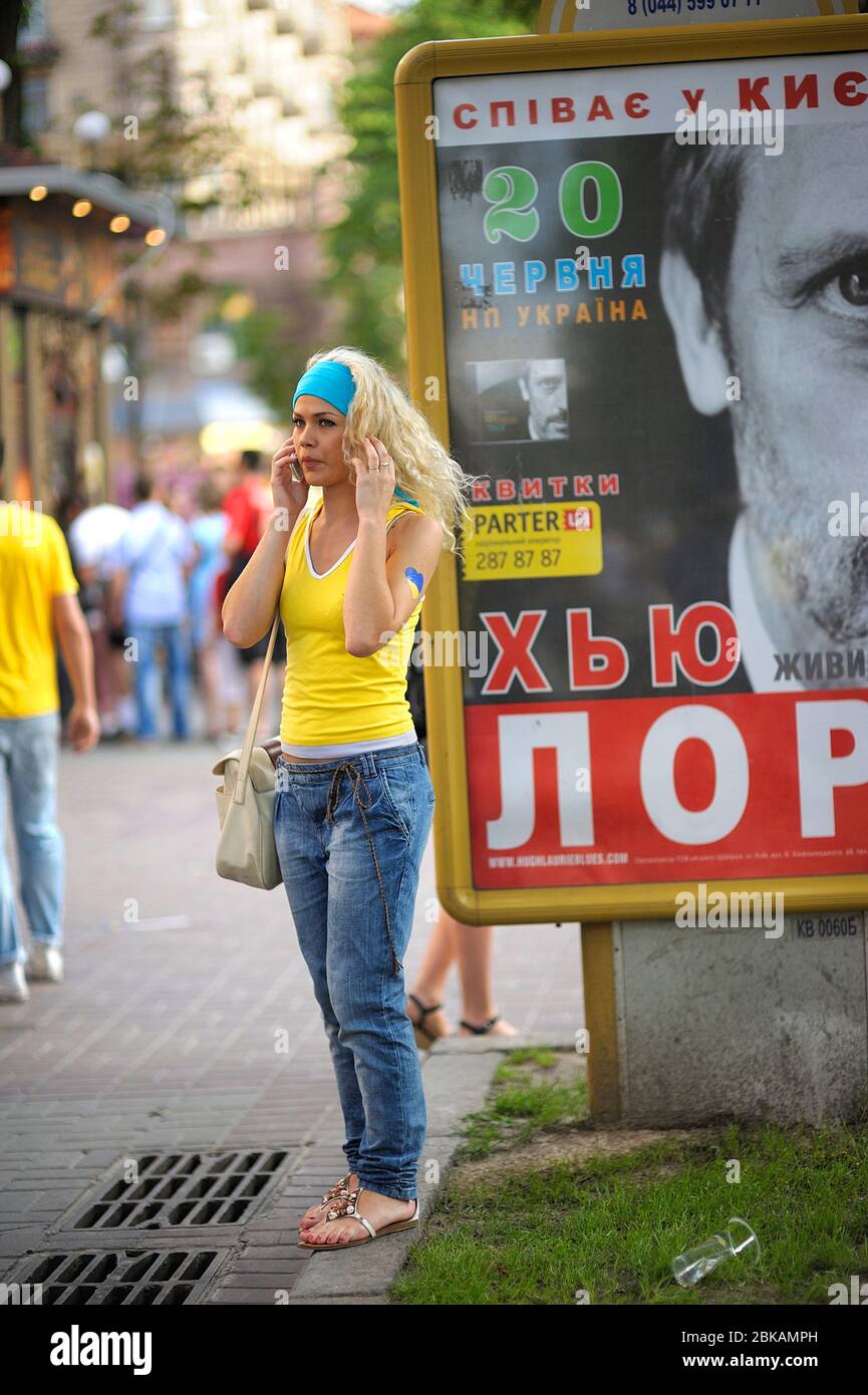 Jeune jolie fille dans un t-shirt jaune et jeans bleus debout sur la rue et  parlant sur le téléphone mobile, style décontracté Photo Stock - Alamy
