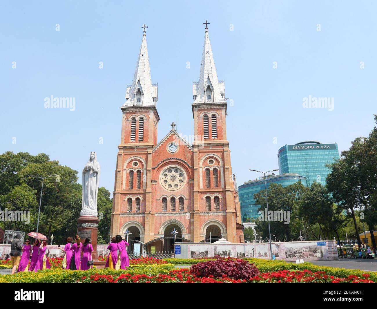 Ho Chi Minh Ville, Vietnam - 30 avril 2020: Un grand groupe de dames en robe traditionnelle vietnamienne brillante devant la cathédrale notre-Dame Banque D'Images