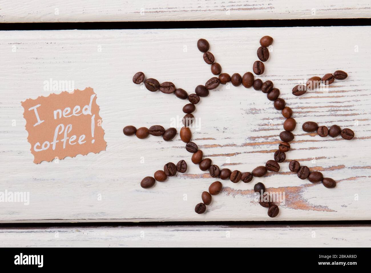 Grains de café torréfiés marron disposés en forme de soleil. Banque D'Images Grains de café torréfiés marron disposés en forme de soleil. Banque D'Images