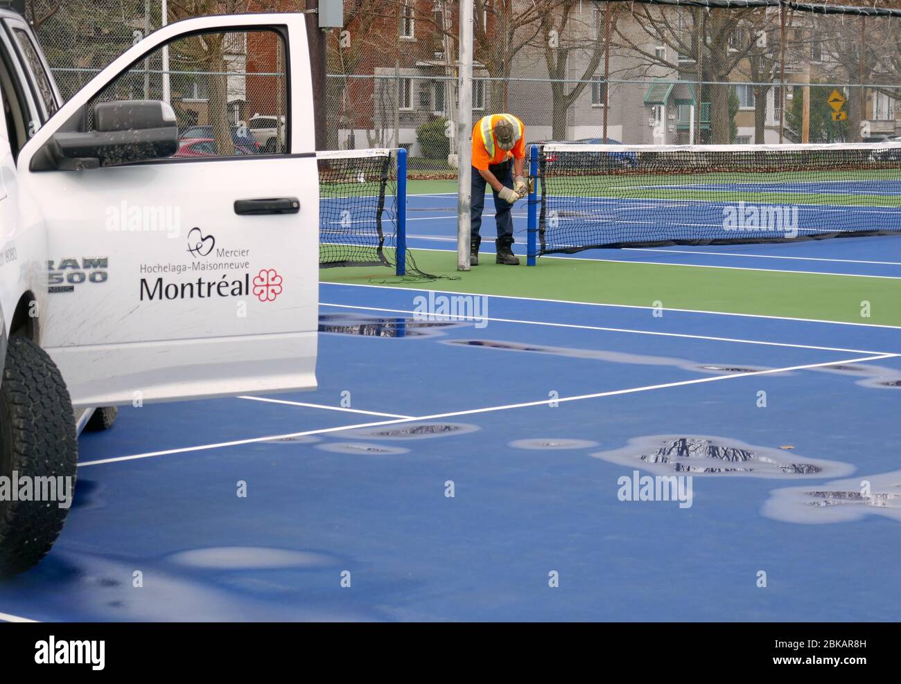 Montréal, Québec, Canada. 3 mai 2020. Alors que la ville se prépare lentement à l'assouplissement des règles, les employés municipaux installent des filets dans les courts de tennis du parc Louis-Riel. Banque D'Images