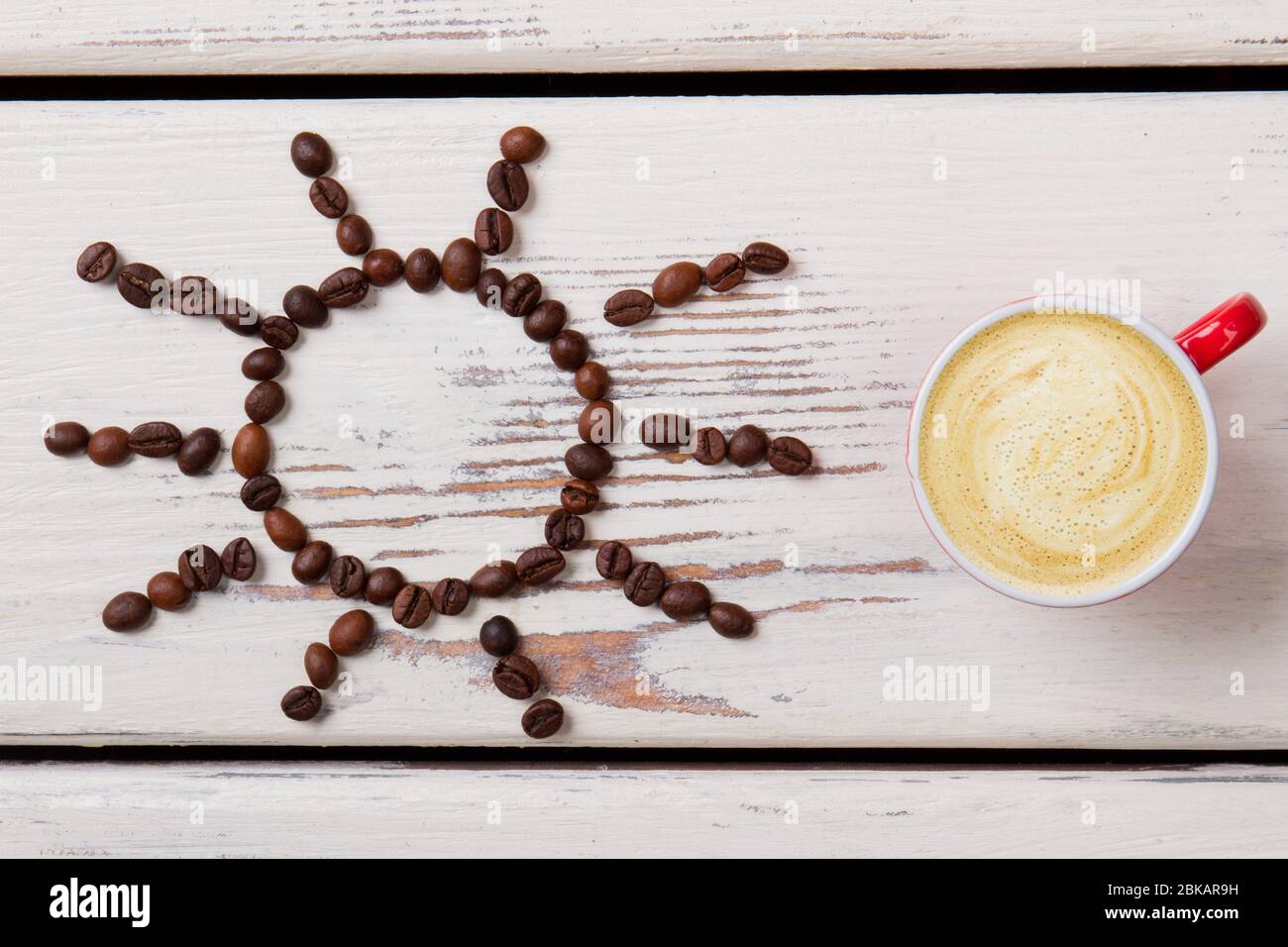 Tasse de café laiteux avec mousse et soleil en haricots. Banque D'Images Tasse de café laiteux avec mousse et soleil en haricots. Banque D'Images