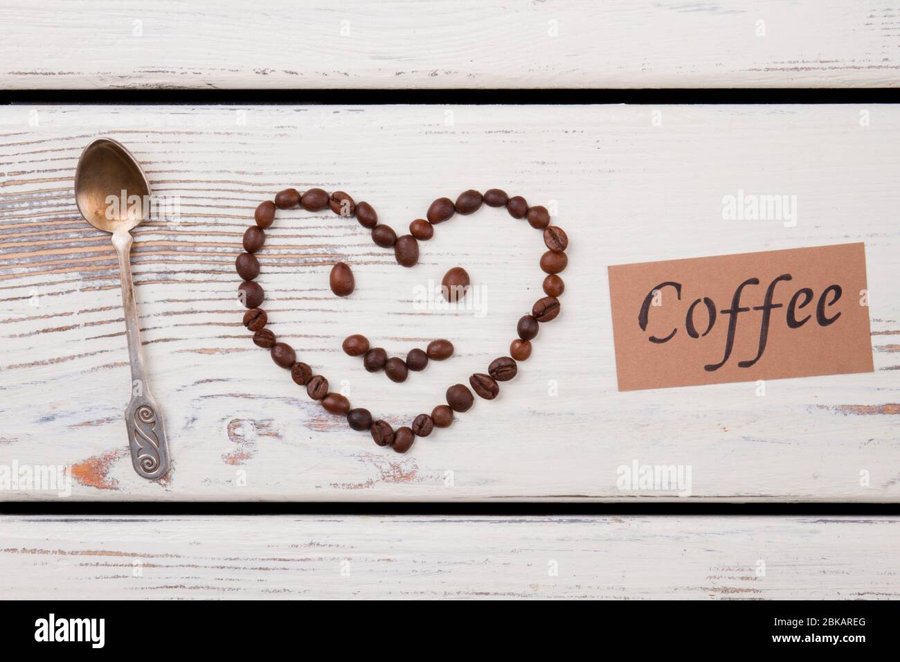 Coeur sourit fait de grains de café et de cuillère à café sur bois. Banque D'Images