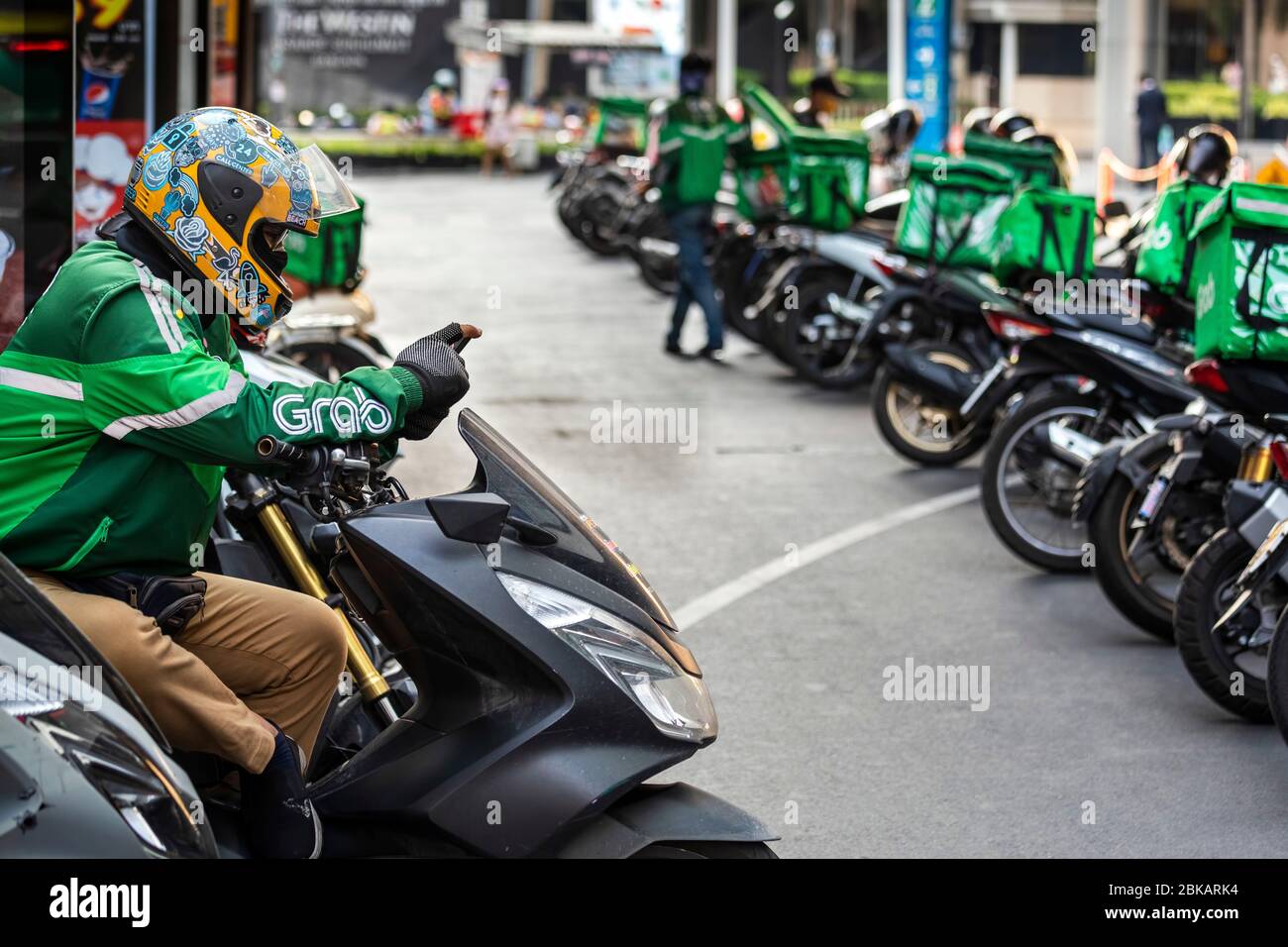 Prenez les coureurs de livraison de moto portant un masque de visage pendant la pandémie de Covid 19, Bangkok, Thaïlande Banque D'Images