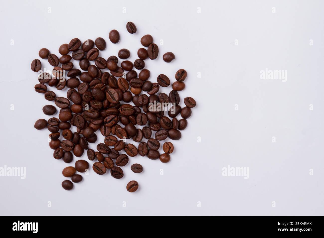 Vue de dessus pile de grains de café fraîchement torréfiés isolés sur blanc. Banque D'Images Vue de dessus pile de grains de café fraîchement torréfiés isolés sur blanc. Banque D'Images