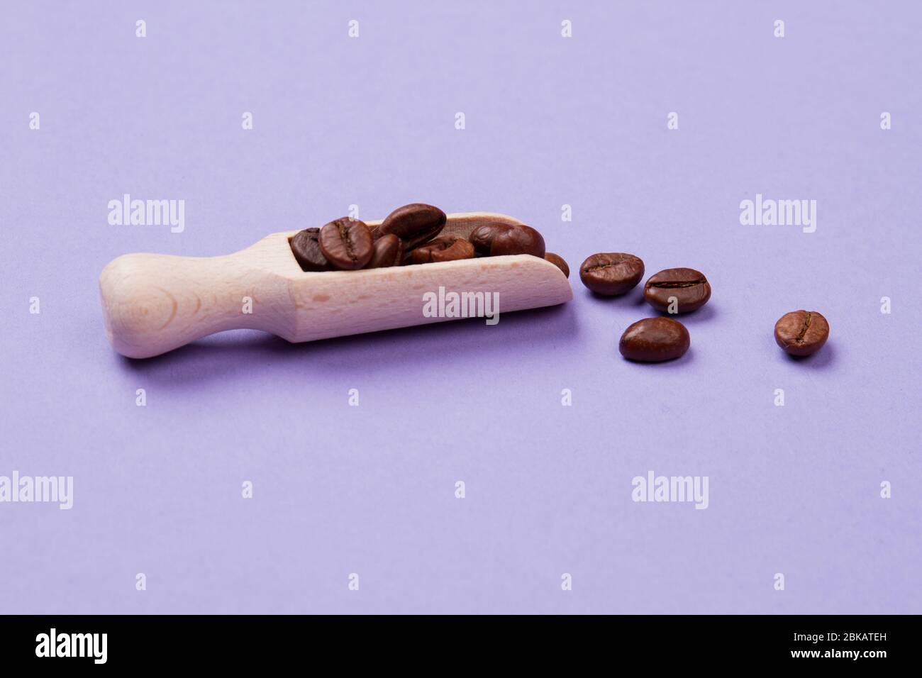 Grains de café dans une petite cuillère ou une pelle en bois. Banque D'Images Grains de café dans une petite cuillère ou une pelle en bois. Banque D'Images