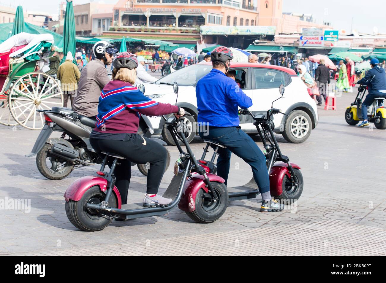 Touristes utilisant le mobile tout en étant à cheval électrique dans la ville de Marrakech (Marrakech), Afrique du Nord Banque D'Images