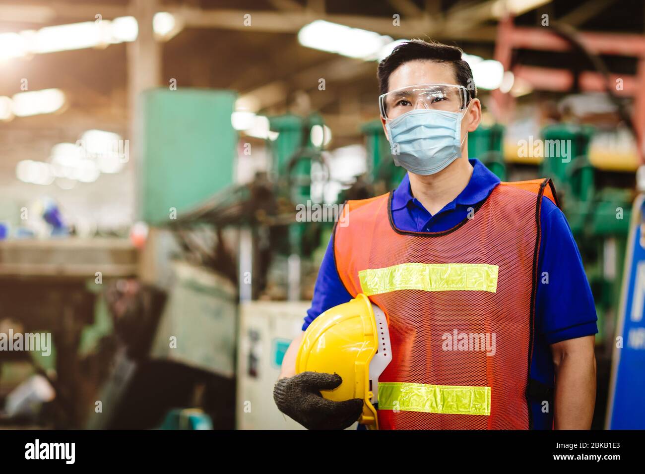 Les travailleurs asiatiques portent un masque facial jetable pour la protection du virus Corona et un filtre anti-pollution de l'air par la poussière de fumée en usine pour des soins de santé. Banque D'Images
