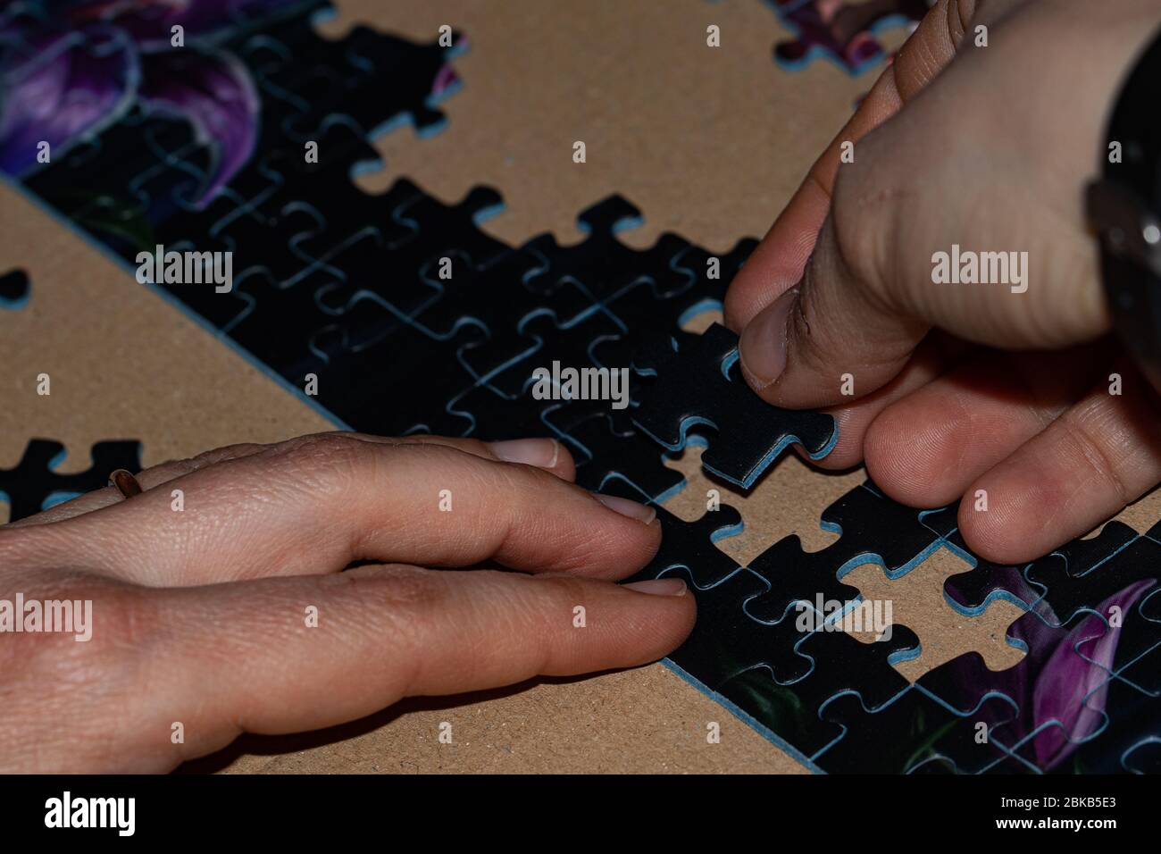 gros plan de deux mains féminines qui composent un puzzle sur le thème de l'imagination Banque D'Images
