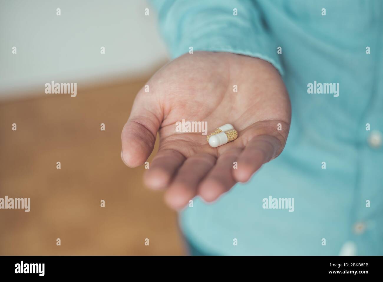Main masculine tenant médicament ou vitamine comprimé dans Banque D'Images