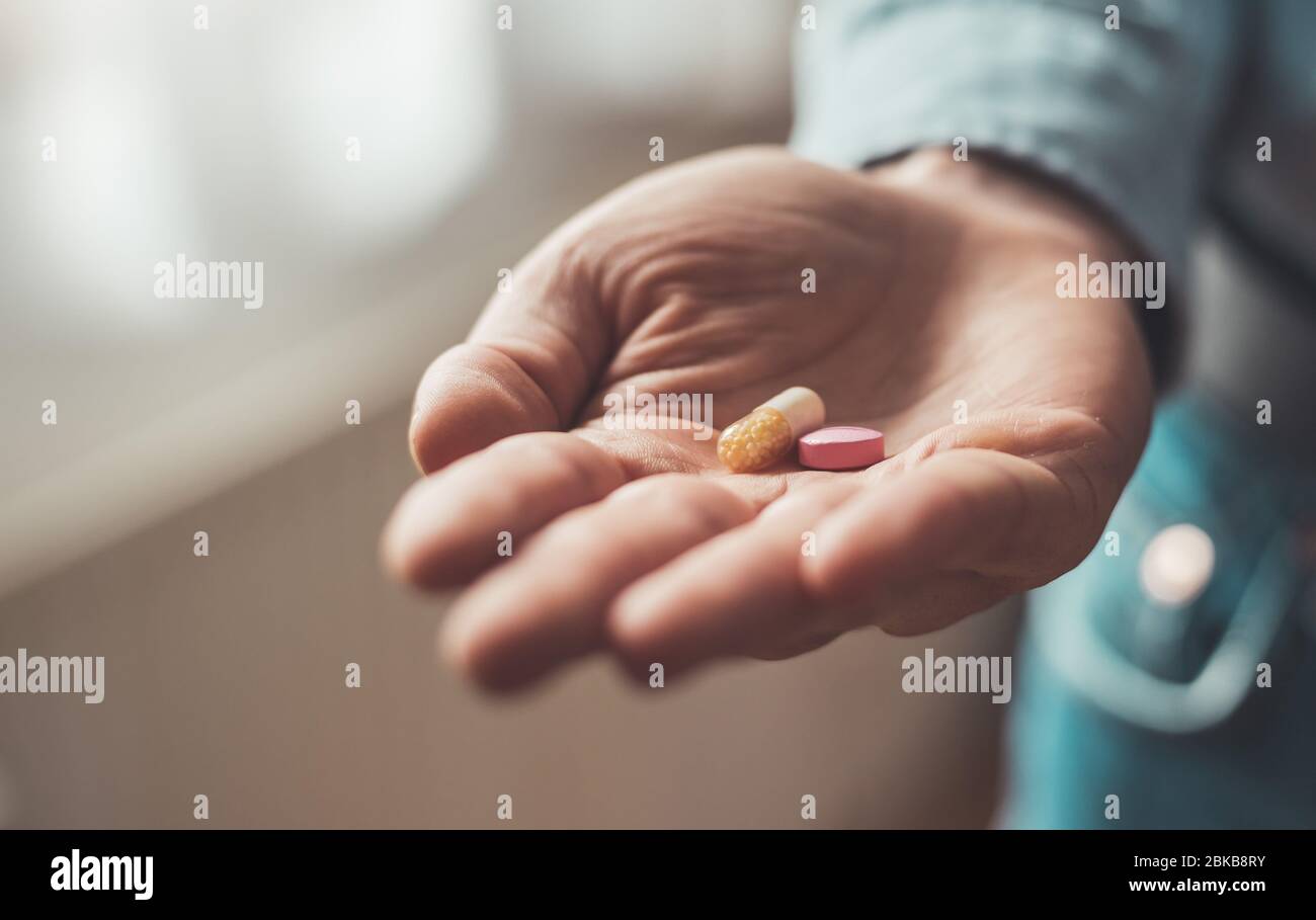 Main masculine tenant médicament ou vitamine comprimé dans Banque D'Images