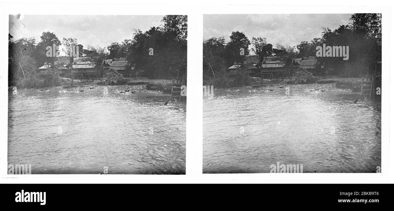 Maisons en bois stilt traditionnelles au bord de l'eau au Cambodge à Mékong ou Tonle SAP. Buffles d'eau debout dans les rives de la rivière. Photo stéréo d'environ 1910. Photo sur la plaque de verre sèche de la collection Herry W. Schaefer Banque D'Images