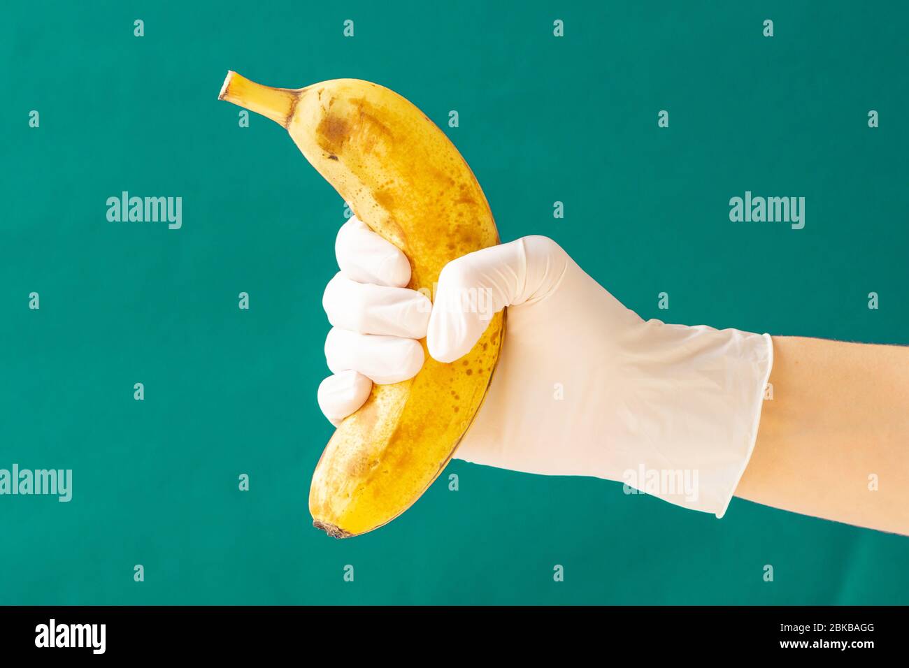 Banane en caoutchouc blanc avec gants. Coronavirus. Copier l'espace. Banque D'Images