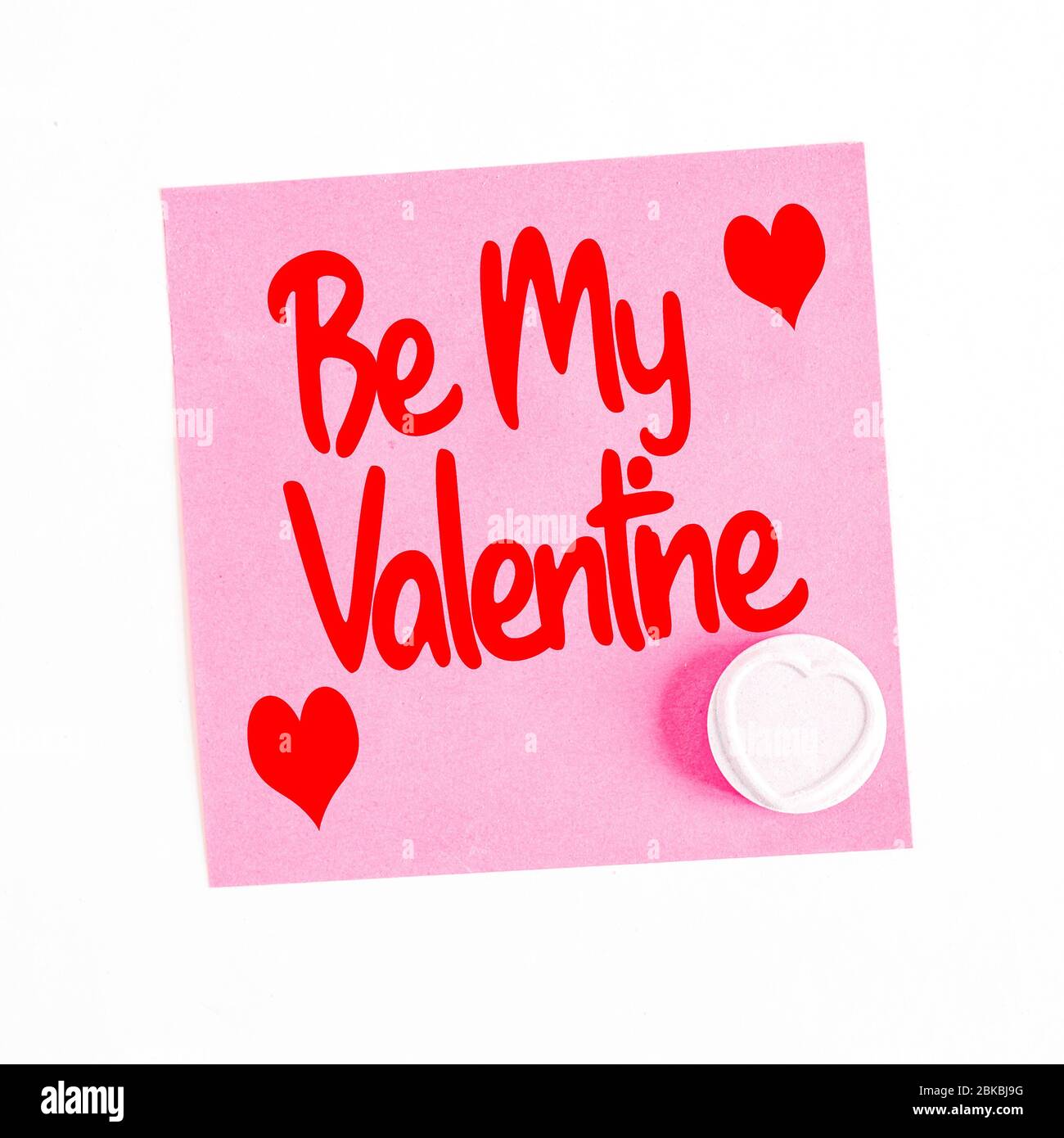Un message romantique laissé sur un pense-bête rose avec l'expression être ma Saint-Valentin et un cadeau d'un coeur d'Amour bonbons ou de la chéri Banque D'Images Un message romantique laissé sur un pense-bête rose avec l'expression être ma Saint-Valentin et un cadeau d'un coeur d'Amour bonbons ou de la chéri Banque D'Images